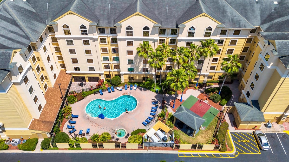 Aerial view of Stay Sky Suites with the outdoor pool, hot tub and basketball court